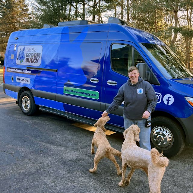Owner Amy outside van with two client pups